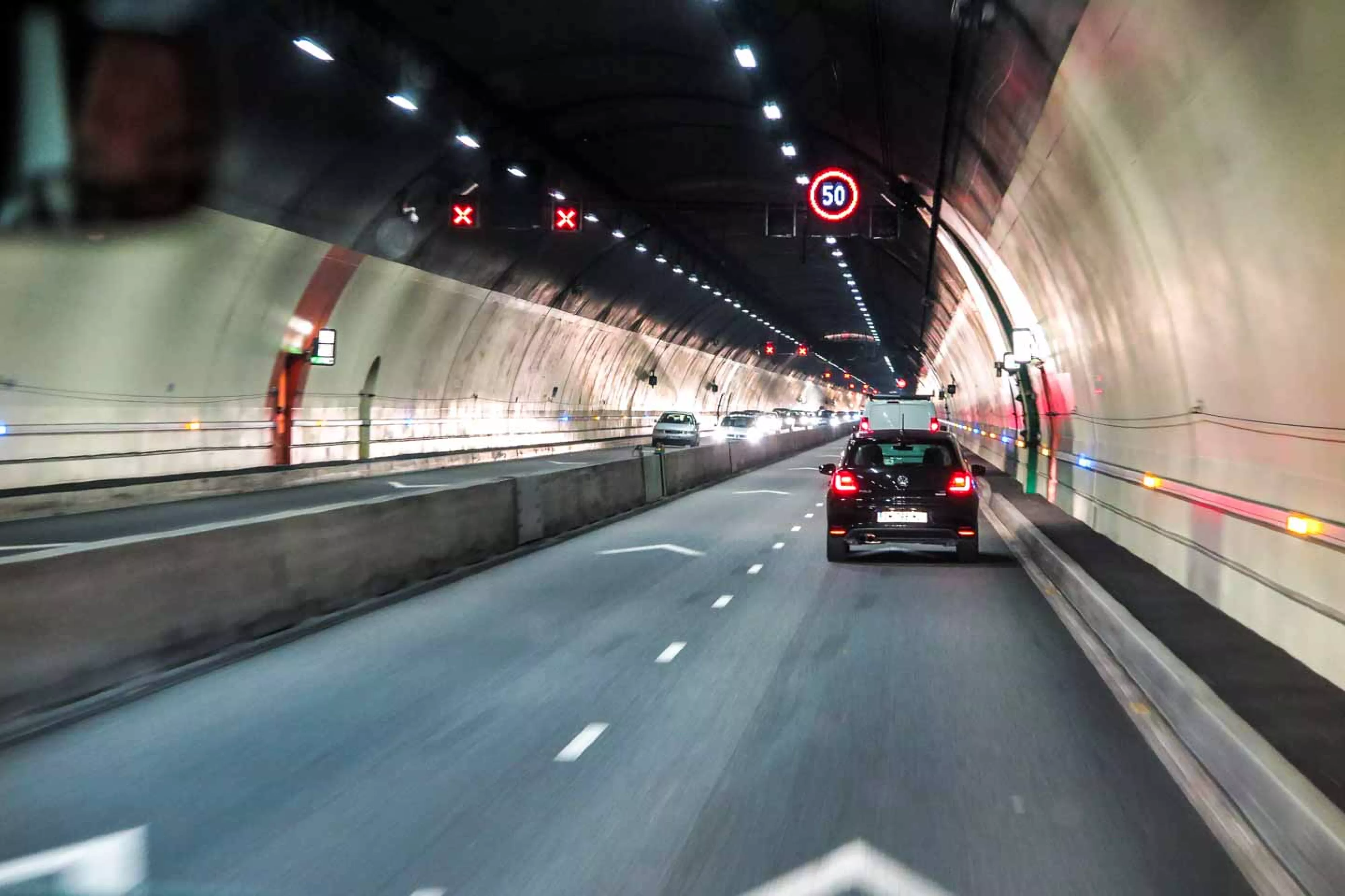 Cars drive through city road tunnel