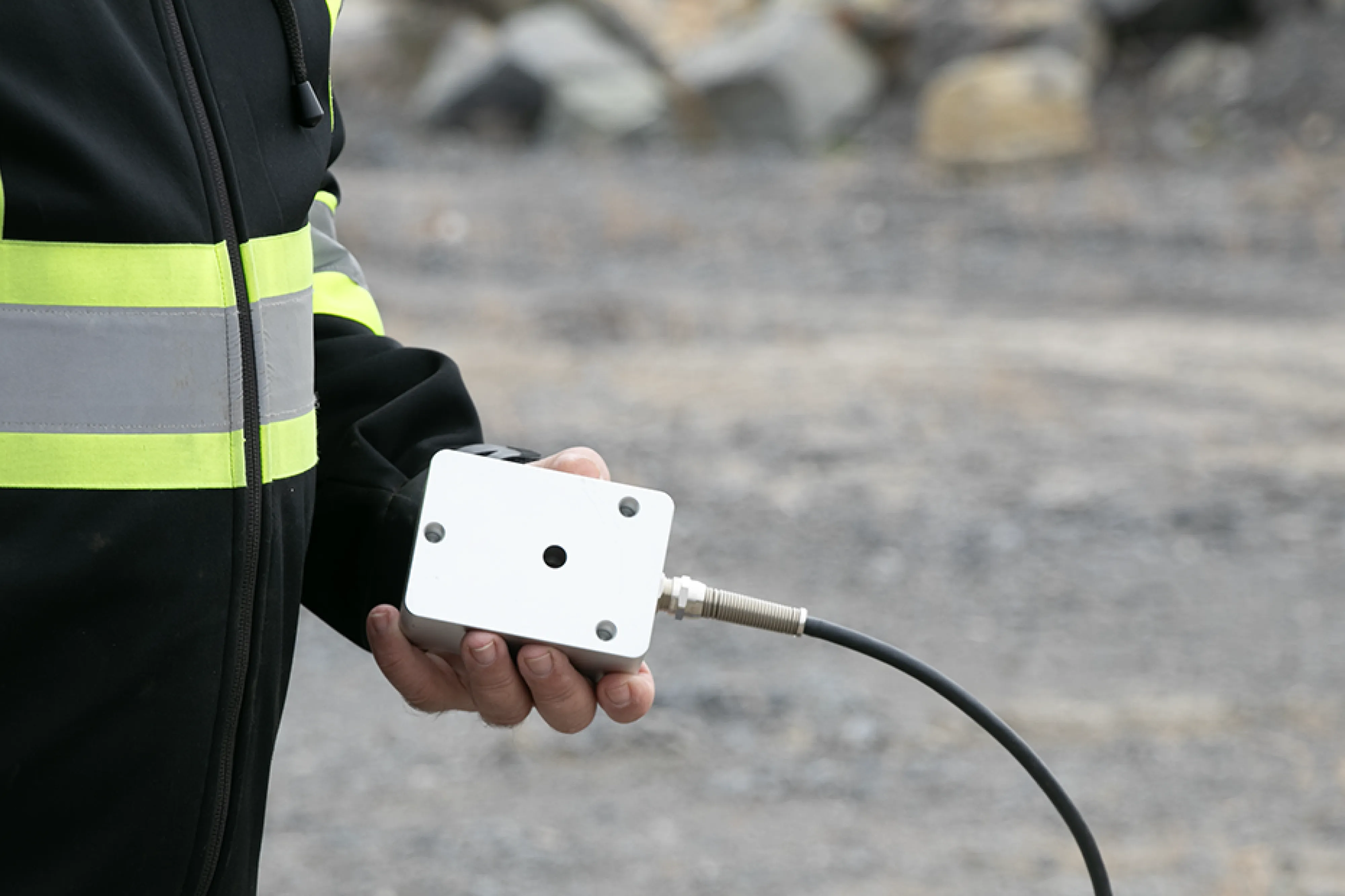 holding a Micromate Plus triaxial geophone