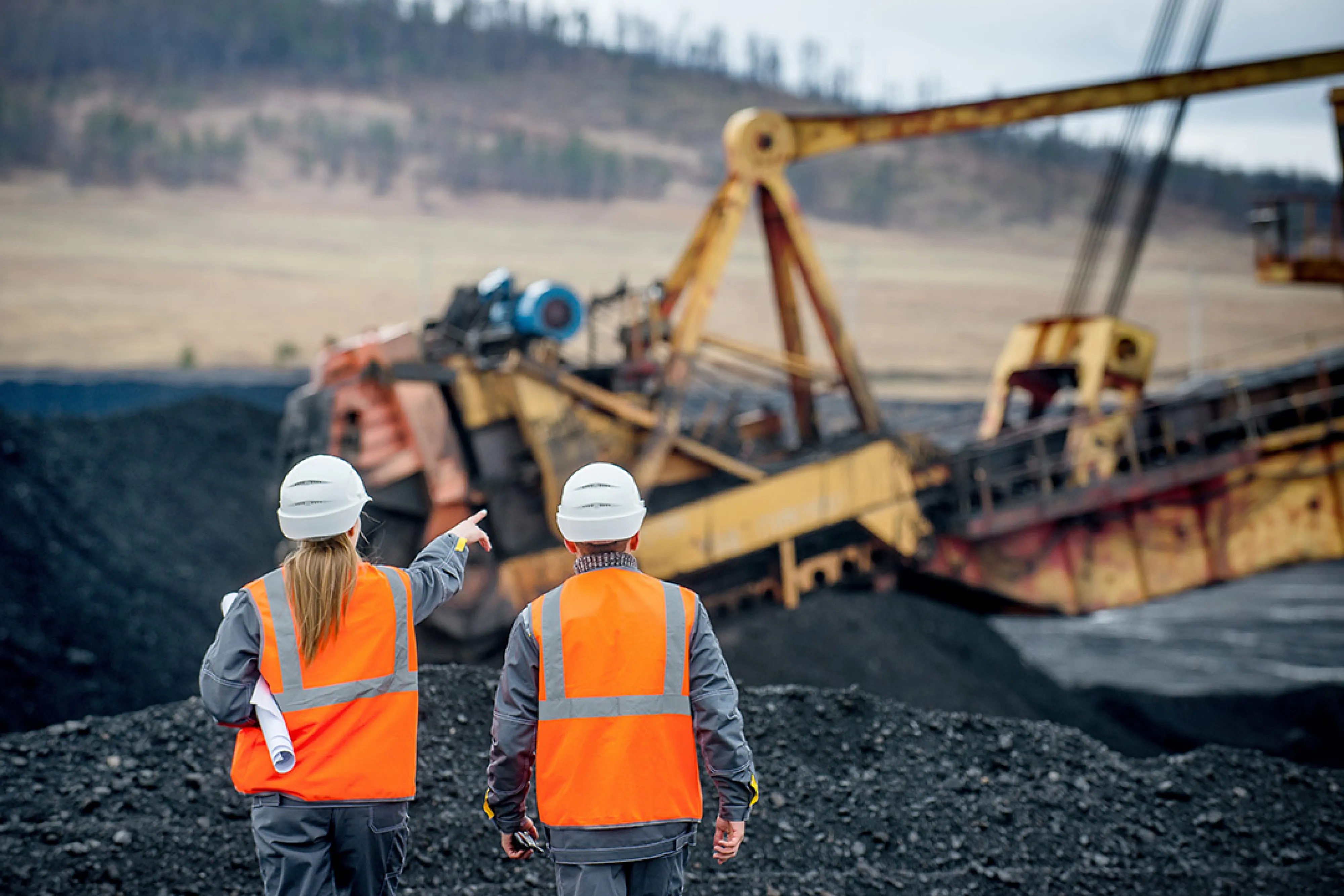 Two workers walking in an open pit mine.