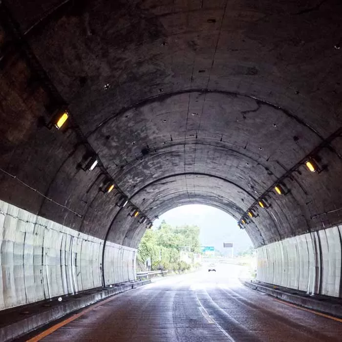 Road passes through dark tunnel