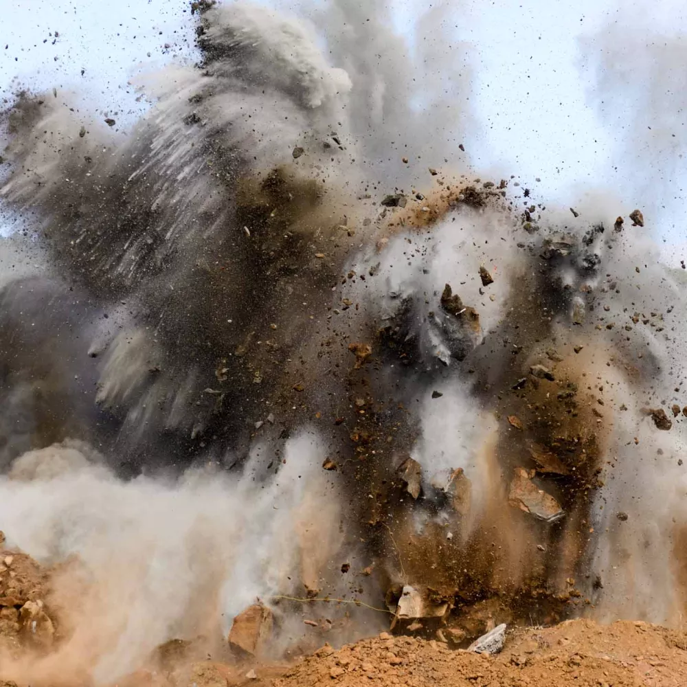 Cloud of dirt explodes from blasting site