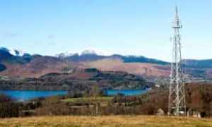 Phone tower next to landscape of mountains and lake