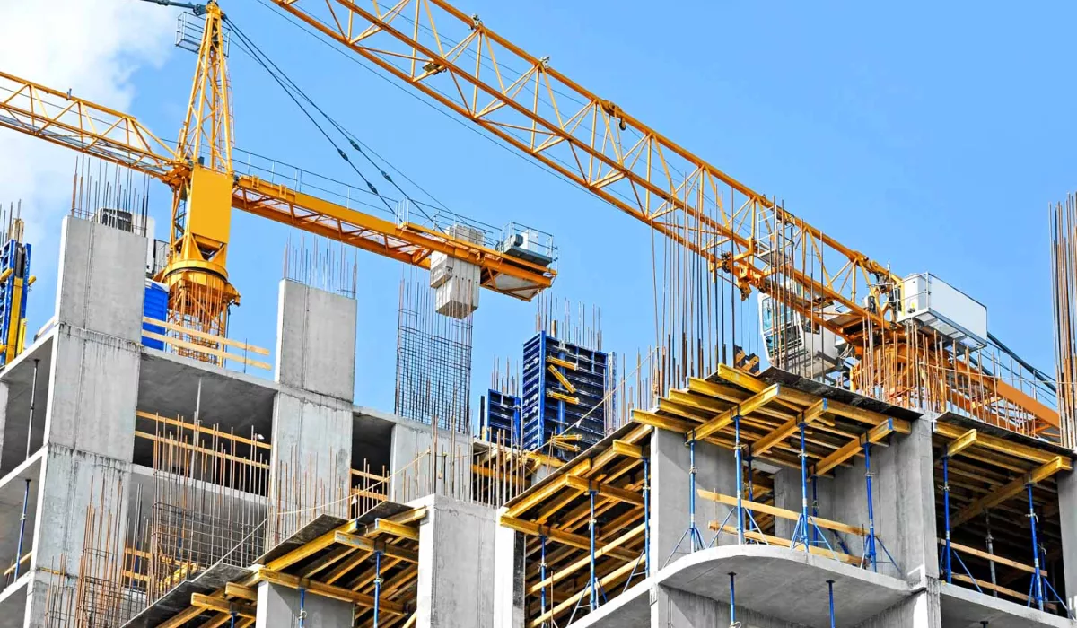 Crane and building construction site against blue sky